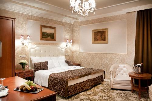 ein Schlafzimmer mit einem Bett, einem Tisch und einem Stuhl in der Unterkunft Hotel Capitulum in Győr