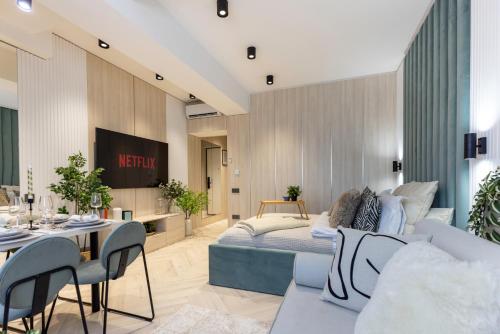a living room with a bed and a table and chairs at AIASTAY Bucharest River Apartments in Bucharest