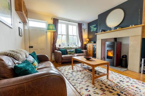 a living room with a couch and a fireplace at DUNELM COTTAGE - Three Bed Cottage in the heart of the Peak District in Edale