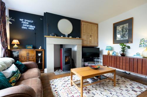 a living room with a couch and a fireplace at DUNELM COTTAGE - Three Bed Cottage in the heart of the Peak District in Edale