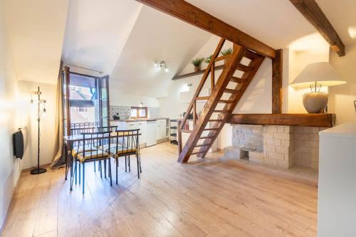 - un salon avec un escalier, une table et des chaises dans l'établissement Petit loft des prisons, à Annecy