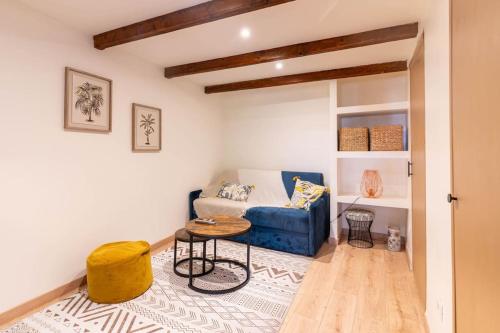 un salon avec un canapé bleu et une table dans l'établissement Petit loft des prisons, à Annecy