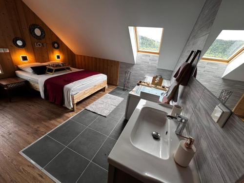 a bathroom with a sink and a bed in a room at Chalet Bois de Rose in La Bresse