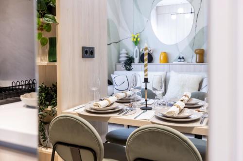 a dining room table with chairs and a dining room table at AIASTAY Bucharest River Apartments in Bucharest