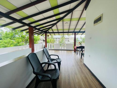 a covered porch with chairs and a table at Mindiya Turtle Waves Talalla in Talalla