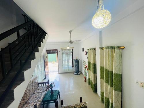 a living room with a staircase and a chandelier at Mindiya Turtle Waves Talalla in Talalla