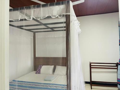 a bunk bed with a canopy in a room at Mindiya Turtle Waves Talalla in Talalla