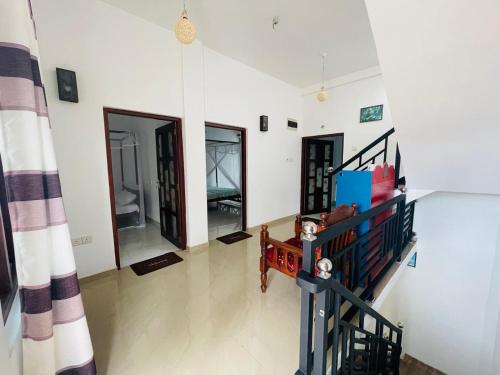 a living room with white walls and a staircase at Mindiya Turtle Waves Talalla in Talalla