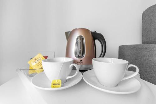 two coffee cups and a tea pot on a table at Vacation paradise in Iseo Lake with many pools in Iseo