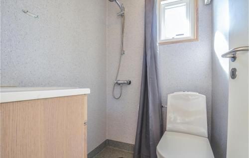 a bathroom with a shower with a toilet and a sink at Hytte 15 in Thyborøn