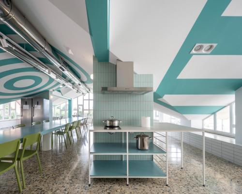 a cafeteria with blue and green walls and tables and chairs at Loop INN Hostel Santiago de Compostela in Santiago de Compostela
