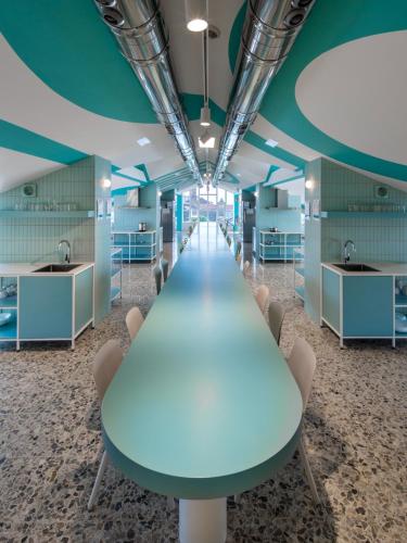 a long conference room with a blue table and chairs at Loop INN Hostel Santiago de Compostela in Santiago de Compostela