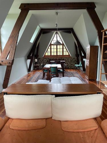 Cette chambre mansardée comprend une table et des chaises. dans l'établissement Our House, Château de la Boulaye, à Cerisy-la-Forêt