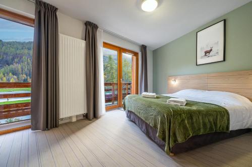 a bedroom with a bed and a large window at Auberge de la Gravière in Orcières