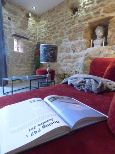 a book sitting on top of a bed at Domaine de Cantegrel - Gîtes de Charme et Suite Troglodyte en Périgord in Vitrac