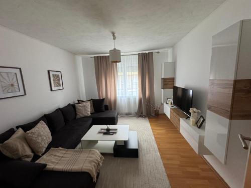a living room with a black couch and a table at Ferienwohnung mitten in Fulda in Fulda