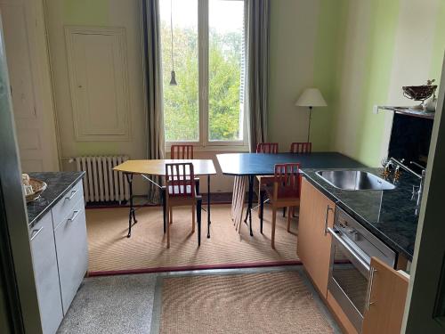 a kitchen with a table and chairs and a table and a window at Our House, Château de la Boulaye in Cerisy-la-Forêt