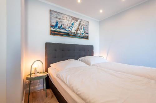 a bedroom with a large white bed and a side table at Haus Christianenhöhe, Whg 09 Capper in Westerland (Sylt)