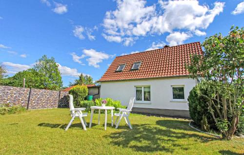 un jardín con 2 sillas y una mesa frente a una casa en Ferienhaus Rheinsberg, en Kleinzerlang