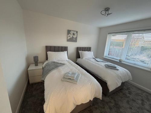 a bedroom with two beds and a window at 2-Beds Sleeps 4 w Parking 15 mins to St Andrews in Anstruther