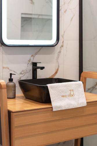 a bathroom with a black sink and a towel at Prive Studio in Thessaloniki