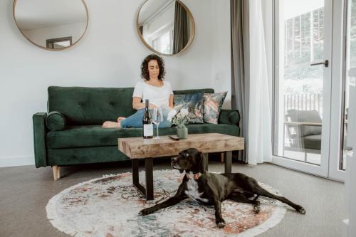 a woman sitting on a couch with a dog in a living room at Boutique Hotel GreenLeaf in Sinzing