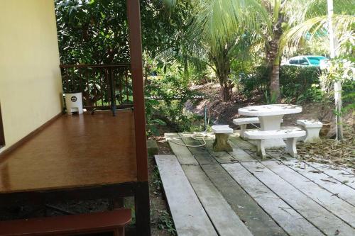 a patio with a table and a picnic table at Ruentonnum Amphawa in Amphawa