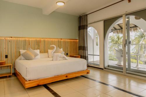 a bedroom with a bed and a large window at Bungalows Zicatela in Puerto Escondido