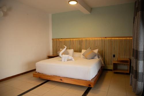 a bedroom with a bed with a stuffed animal on it at Bungalows Zicatela in Puerto Escondido