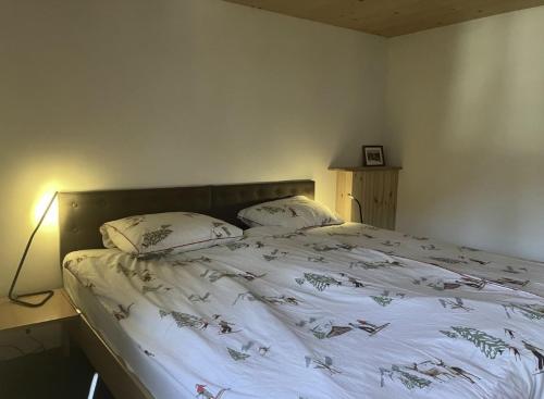 a bed with two pillows on it in a bedroom at Casa Vanellus / Vignogn / Val Lumnezia / near Laax in Vigens