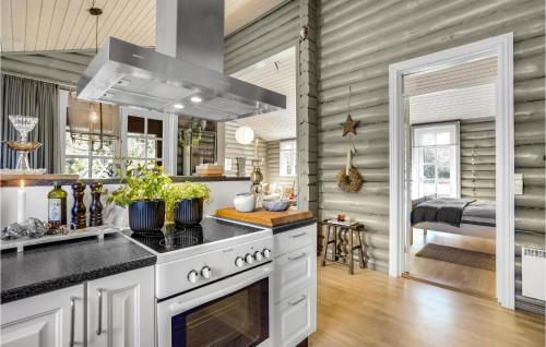 a kitchen with white cabinets and a stove top oven at 3 Bedroom Amazing Home In Sæby in Sæby