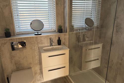 a bathroom with a shower and a sink and a mirror at 2-Beds Sleeps 4 w Parking 15 mins to St Andrews in Anstruther