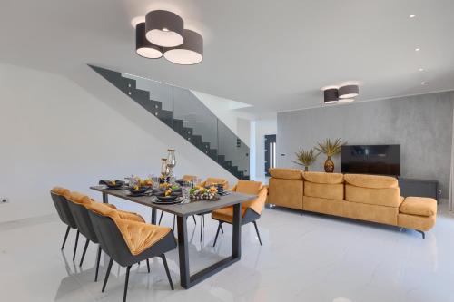 Un comedor con una mesa y sillas y un sofá. en Villa Tonchi 3 Bedroom Private Pool BBQ & Garden, en Barban