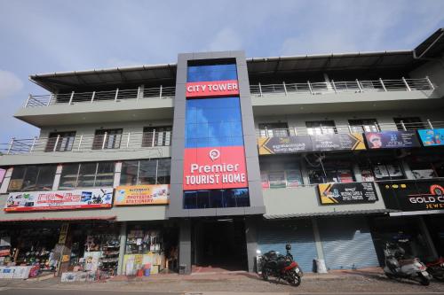 a building with a sign in front of it at Premier Tourist Home in Kunnamkulam