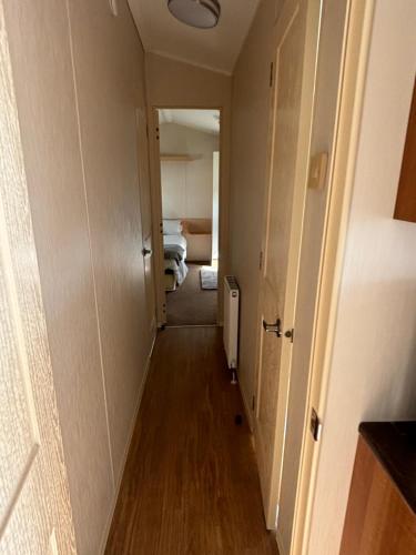 a hallway leading to a room with two beds at Beautiful , spacious two bedroom caravan home in Eastchurch