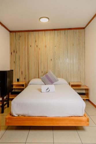 a bedroom with a bed with a sign on it at Bungalows Zicatela in Puerto Escondido
