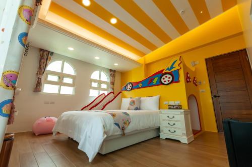a childs bedroom with yellow walls and a bed at Michelin Castle - Yilan Homestay in Wujie