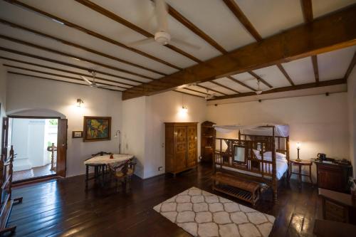 a large room with a bed and a table at Old Courtyard Hotel in Cochin