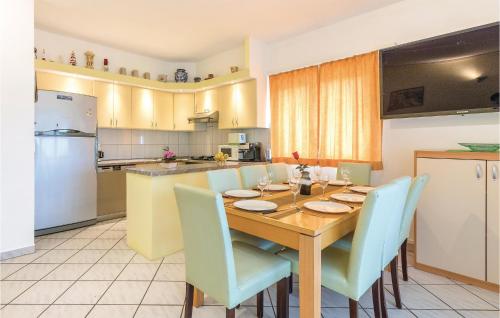 a kitchen with a wooden table and blue chairs at Nice Apartment In Stinjan in Štinjan
