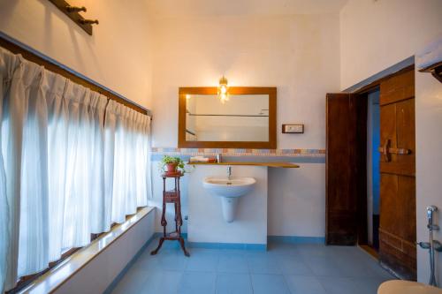 a bathroom with a sink and a mirror at Old Courtyard Hotel in Cochin