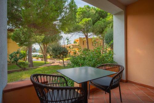 a table and chairs on a balcony with a view of a street at Felix Hotels - Residence Hotel Costa Serena in Palau