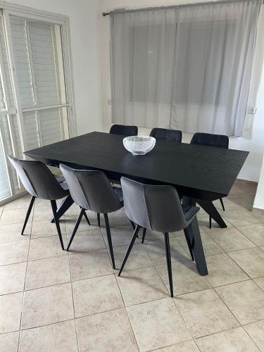 a black dining table and chairs in a room at גבוה בגלבוע in Gan Ner