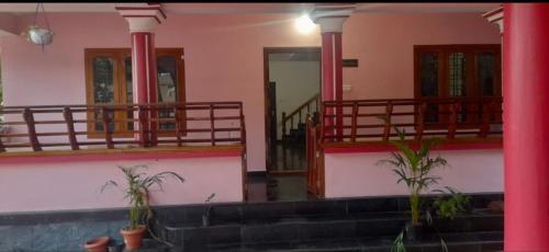 a house with two potted plants on the stairs at Vintage villa in Varkala