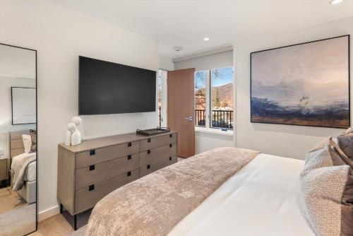 アスペンにあるNew Listing 3BR 3BA Aspen Condoの壁に大きなテレビが掛かっている寝室