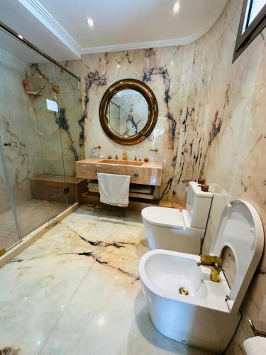 a bathroom with a toilet and a sink and a mirror at villa pour location vacances in Tamaris