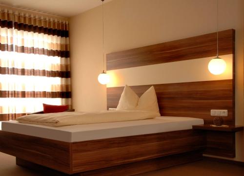 a bedroom with a bed with two lights on it at Brauereigasthof Püttner in Schlammersdorf