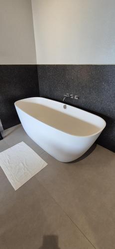 a white bath tub sitting on the floor of a bathroom at Pousada dos Ingleses in Bombinhas