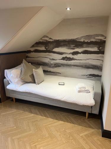 a bed in a room with a painting on the wall at 'Clyde' in ApartNest Auchterarder in Auchterarder