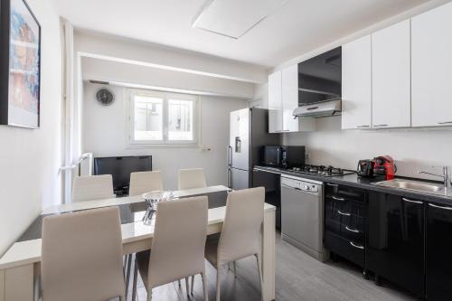 une cuisine avec une table et des chaises dans une cuisine dans l'établissement Bright & Contemporary 2BD Apartment, à Paris