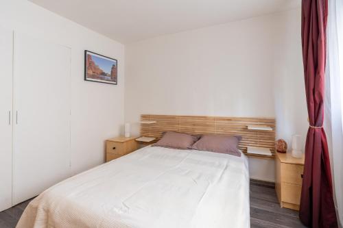 une chambre avec un lit blanc avec une tête de lit en bois dans l'établissement Bright & Contemporary 2BD Apartment, à Paris
